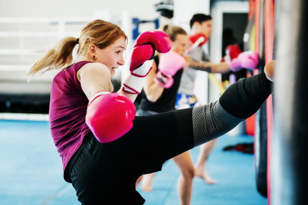 A group of women kickboxing and training together at their local gym. A group of women kickboxing and training together at their local gym.